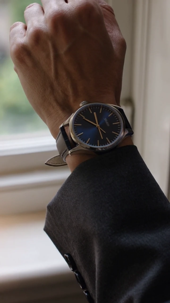A watch rests on a wooden tray, is fastened at the window, and catches the daylight. This 15-second vertical film closes with the generated line, “Time for what matters.”